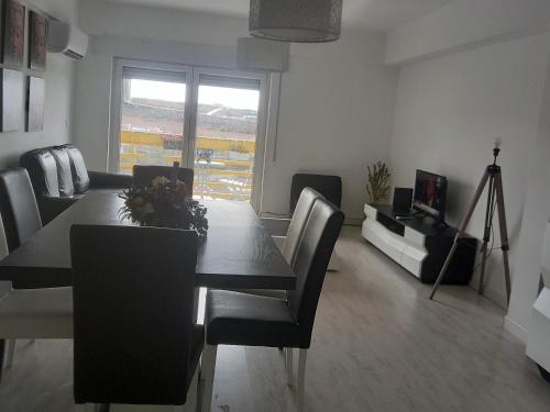 a dining room with a table and chairs and a television at Vista para a serra in Bragança