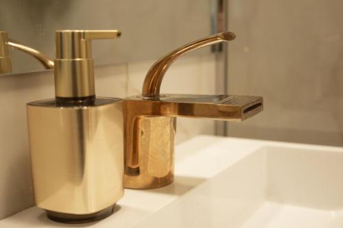 a bathroom sink with a gold faucet next to a sink at Tina Home in Cluj-Napoca