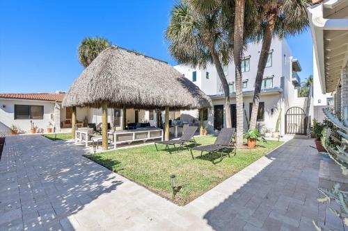 a patio with two chairs and a thatch roof at Walnut By The Sea in Hollywood