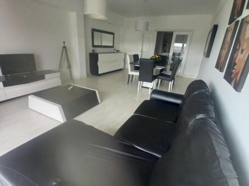a living room with a black leather couch and a table at Vista para a serra in Bragança
