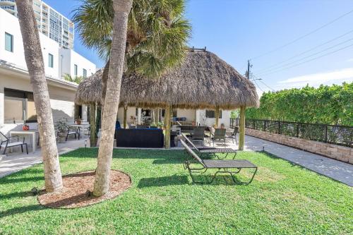 a hut with a bench and two palm trees at Walnut By The Sea in Hollywood