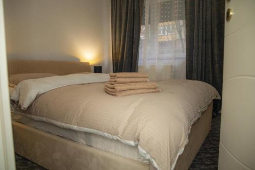 two towels are stacked on a bed in a bedroom at Tina Home in Cluj-Napoca