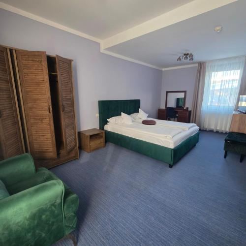a bedroom with a bed and a chair and a couch at Conacul Domnesc in Suceava
