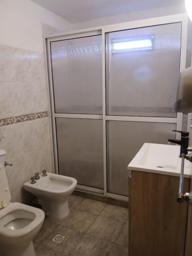 a bathroom with a toilet and a shower and a sink at Carlos Paz Hostel Lodge in Villa Carlos Paz