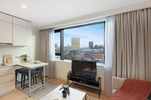 a living room with a table and a large window at Stylish Studio in Manchester in Manchester