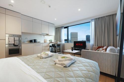 a bedroom with a large bed and a kitchen at Stylish Studio in Manchester in Manchester