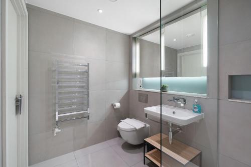 a bathroom with a toilet and a sink and a mirror at Stylish Studio in Manchester in Manchester