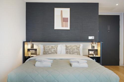 a bedroom with a large bed with two pillows on it at Stylish Studio in Manchester in Manchester
