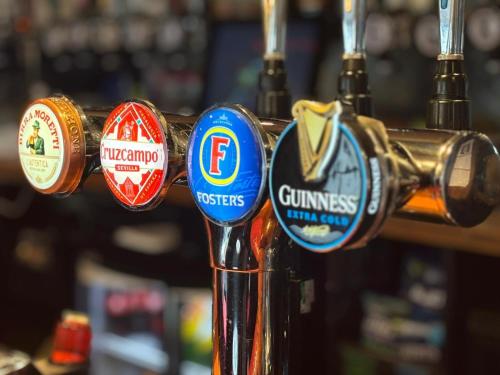 a bar with lots of different types of badges at The Swordfish Inn in Penzance
