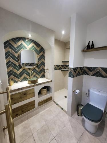 a bathroom with a toilet and a sink and a mirror at Bas de villa moderne avec piscine in Fréjus