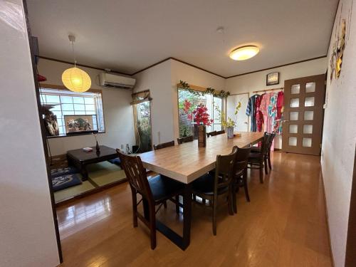 a dining room with a large wooden table and chairs at 新宿駅2分 jr新大久保駅徒歩8分 歌舞伎町徒歩10分 in Tokyo