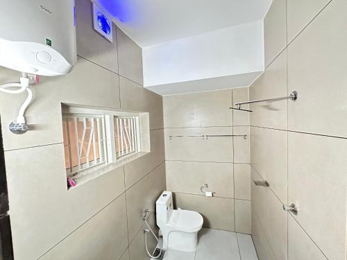 a small bathroom with a toilet and a window at Bloom Fort Villa in Kannur