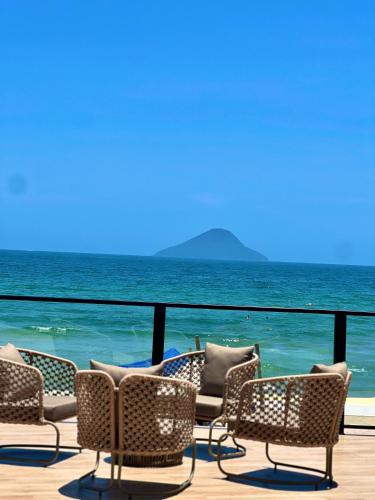 a deck with chairs and the ocean in the background at Casatua Pousada in Juquei