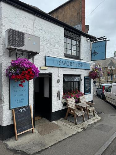 a white building with a sign that reads the snowforest inn at The Swordfish Inn in Penzance