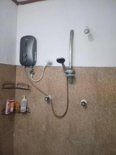 a shower in a bathroom with a phone on the wall at BG Guest House Jaffna in Tirunelveli East