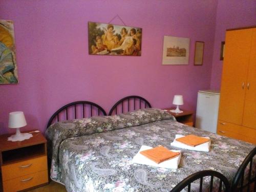 a bedroom with a bed and a purple wall at Soggiorno Petrarca in Florence