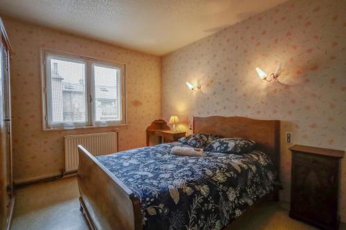 a bedroom with a bed with a blue comforter at Vintage House in Ambérieu-en-Bugey