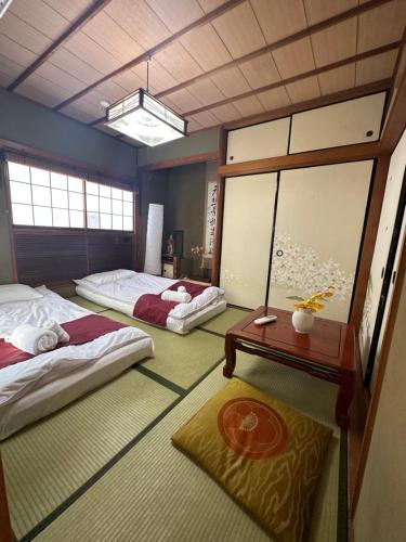 a room with two beds and a table in it at 新宿駅2分 jr新大久保駅徒歩8分 歌舞伎町徒歩10分 in Tokyo