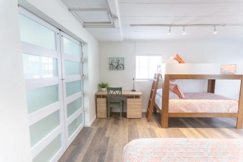 a bedroom with two bunk beds and a desk at Beachside Bungalow steps from sand in San Diego