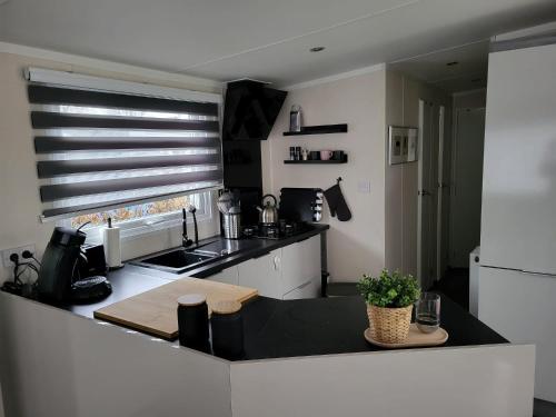 a kitchen with a black counter top and a white refrigerator at Huis Frieda am See, Nähe Arnheim in Lathum