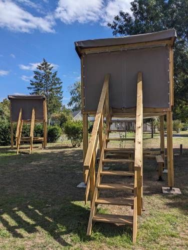 a play house with a ladder in the grass at Camping Onlycamp Tours Val de Loire in Saint-Avertin