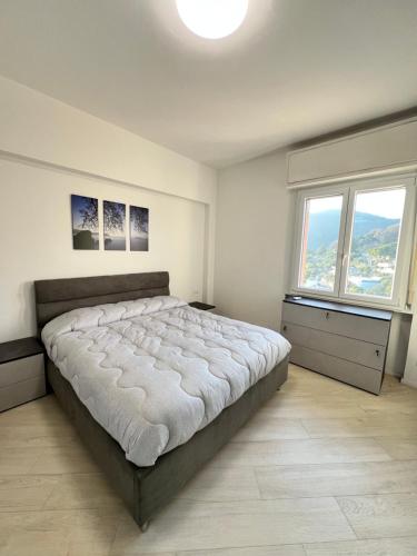 a bedroom with a large bed and two windows at Bergeggi Sea View Apartment - Torre del Mare in Bergeggi