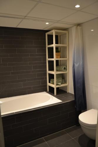 a bathroom with a bath tub and a toilet at Nature and tranquility in Soest with Forest, Dunes and City in Soest