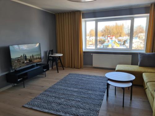 a living room with a couch and a flat screen tv at Spacious and quiet 2BR apartment in Tartu