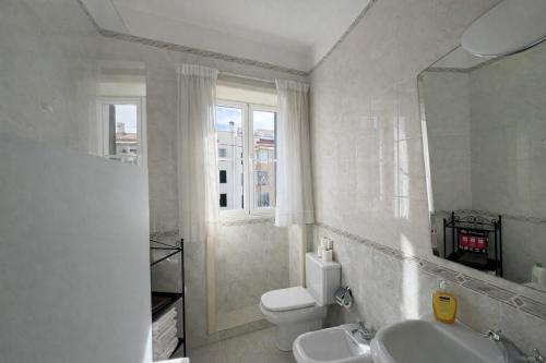 a white bathroom with a toilet and a sink at Violeta House in Funchal