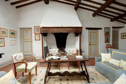 a living room with a table and a fireplace at Villa Le Barone in Panzano