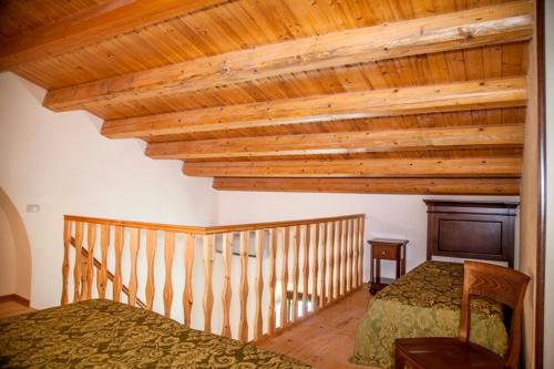 a bedroom with a bed and a wooden ceiling at Feudo Bauly in Palazzolo Acreide