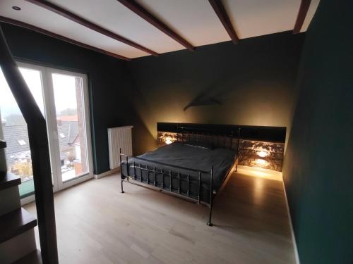 a black bedroom with a bed and a window at Haus Auszeitblick in Bad Bentheim