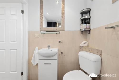 a bathroom with a white toilet and a sink at Dean Park 2-Bed Unit in Deer Park