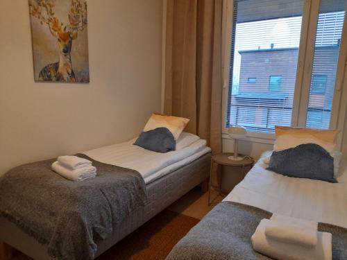 two beds in a small room with a window at Spacious Apartment for 4 with Sauna in Oulu