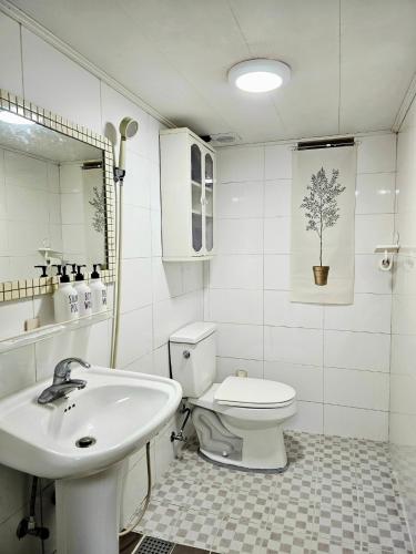 a white bathroom with a sink and a toilet at Stay Onyu in Seoul
