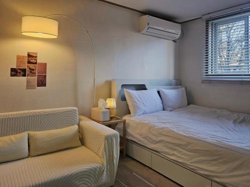 a small room with a bed and a couch at Stay Onyu in Seoul