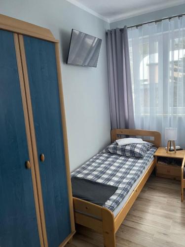 a small bedroom with a bed and a window at Pokoje Gościnne in Ujsoły