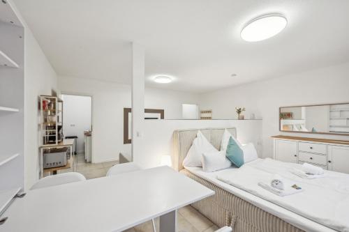 a white room with two beds and a table at Ramoni Apartments - Bergzauber Kniebis in Freudenstadt