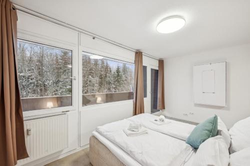 a bedroom with a bed and a large window at Ramoni Apartments - Bergzauber Kniebis in Freudenstadt