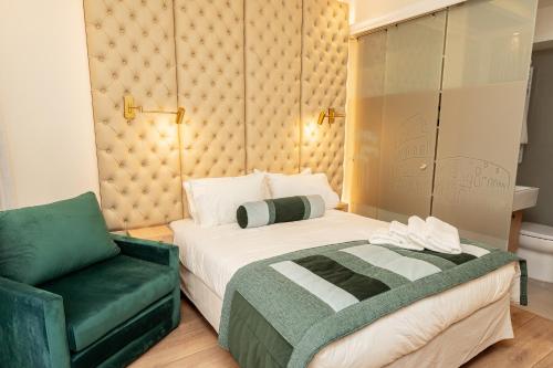 a bedroom with a bed and a green chair at Casa D'Agostino in Santiago