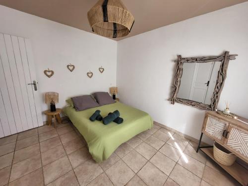 a bedroom with a green bed and a mirror at Bas de villa moderne avec piscine in Fréjus