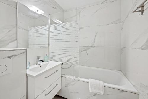 a white bathroom with a shower and a sink at Ramoni Apartments - Lichtblick in Enzklösterle