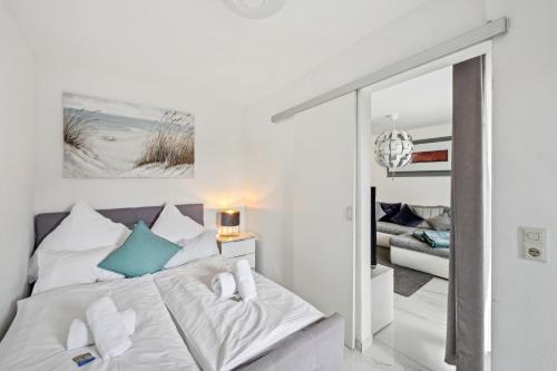 a white bedroom with a bed and a mirror at Ramoni Apartments - Lichtblick in Enzklösterle