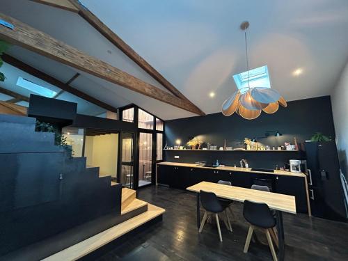 a dining room with a table and a kitchen at Loft contemporain in Bordeaux