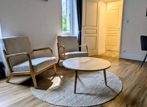 two chairs and a coffee table in a room at La Suite Gignac in Gignac