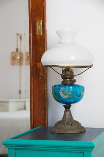 a lamp on a blue table in a bathroom at Aminta Home in Las Palmas de Gran Canaria