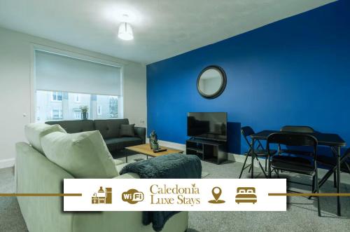 a living room with a couch and a blue wall at Kirkview Apartment in Kirk of Shotts