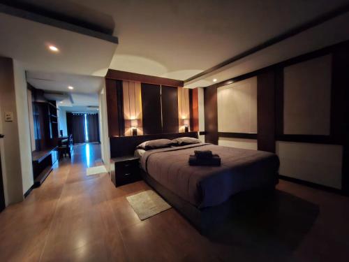a bedroom with a large bed and wooden floors at Arizona Residence in Ban Ko En