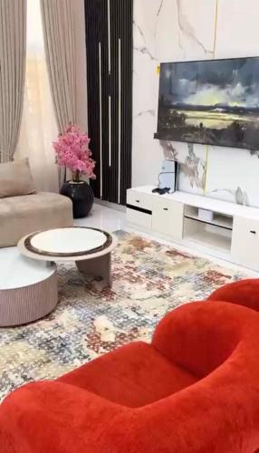 a living room with a couch and a tv at 5bedroom duplex self compound in Lekki
