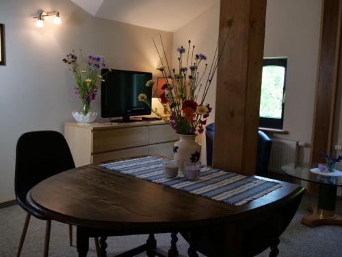 a room with a table with flowers and a tv at Apartment Turmwohnung by Interhome in Kuchelmiß